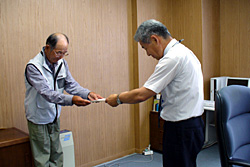 代表者の佐藤さんに支援金を贈呈する柴田事務局長